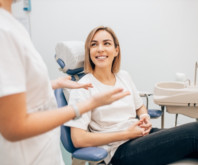 Woman smiling while visiting her dentist in Little Ferry New Jersey