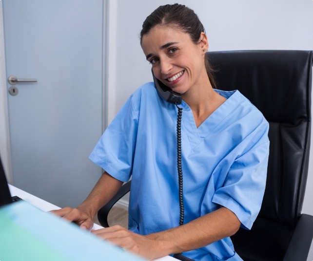 Smiling dental team member on the phone