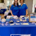 Two dental team members at table with Erin Dental information at community event