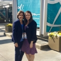 Two dental team members in front of large sign at community event