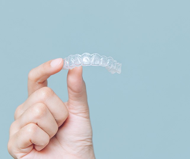Closeup of patient holding clear aligner