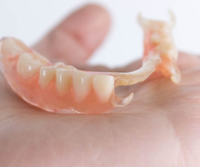 Hand holding a partial denture