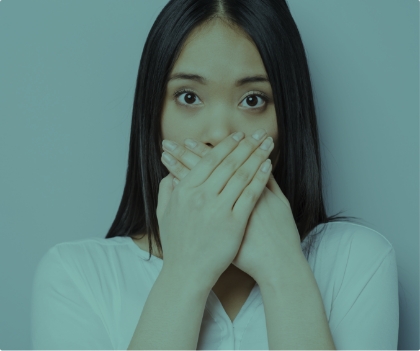 Fearful patient in need of sedation dentistry covering her mouth