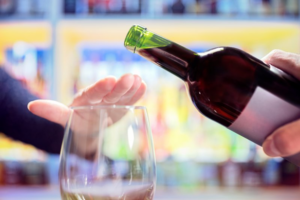 Individual holding a hand out to refuse red wine